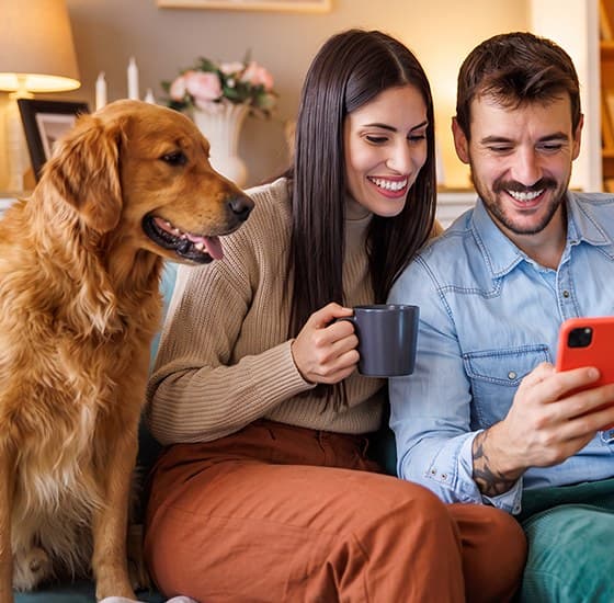 Couple relaxing at home with their dog after buying a car online